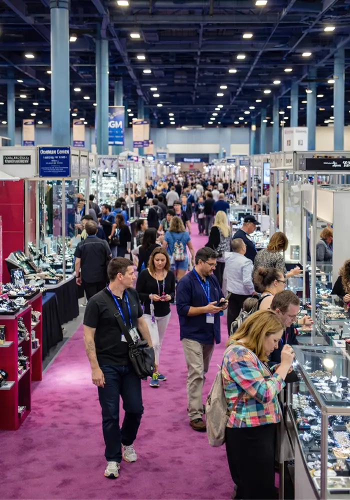 Jewelers International Showcase (JIS) trade show floor at Miami Beach Convention Center with buyers and jewelry display cases